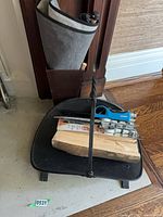 Overall view of black metal log tray, rectangular holder behind it, some lighters visible