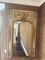 Full view of trumeau mirror mounted on wall showing overall design and ornament