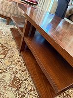 Angled view showing top surface and lower shelves of coffee table