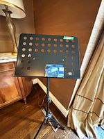 Front view of black perforated steel desk on stand