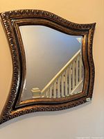Front view of entire wavy gilded mirror