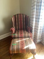 Full view of wingback chair and ottoman showing upholstery pattern and legs