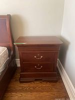 Nightstand front and side view next to bed