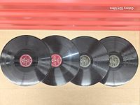 Four 78 RPM records laid flat label side up