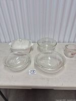 Entire lot showing four casseroles with lids and measuring cup