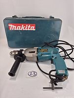 Drill with side handle, chuck key and Makita case