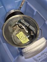 Blue tote containing stainless stock pot with glass lid, kettle body, saucepan, white lid