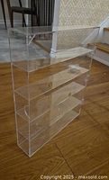 Assembled clear acrylic display case showing five tiers and hinged front door
