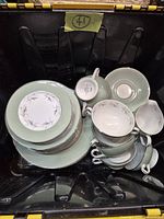 Top view of bin showing stacked plates, cups and creamer