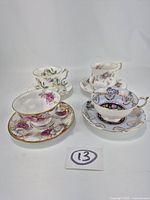 All four bone china teacup and saucer sets displayed together