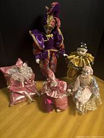 Group of five porcelain clown dolls on table