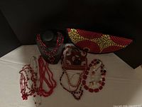 Full lot: six red necklaces, beaded jewelry box, Ankara clutch
