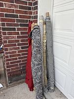 Five fabric bolts leaning against wall showing colors and patterns