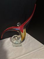 front view of red and clear hand blown glass sculpture on base