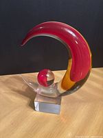 Front view of red and amber Murano glass sculpture on clear base