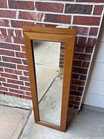 Front view of wood-framed full-length mirror cabinet
