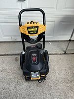 Front view of Dewalt 3300 PSI pressure washer showing frame, hose, Honda engine cover