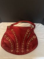 Front view of red Cole Haan purse showing grommet detail