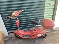 Full side view of red Terminator electric scooter with rear storage box
