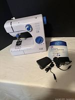 Front view of Easy Home sewing machine with foot pedal, adapter, manual