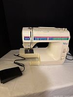 Front and side view of White Jeans Machine sewing machine with foot pedal visible