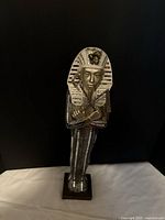 Front view of pharaoh statue on square base showing mirrored glass body