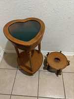 Heart-shaped curio table and fishbowl stand side by side