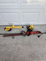 Both trimmers laid on driveway showing full view