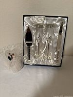 Boxed set showing two flutes, cake knife, cake server with MR & MRS handles alongside bride and groom topper