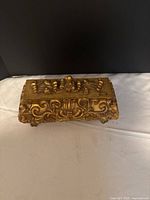Top view of gold carved wooden storage box with ornate lid
