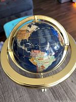 Front view showing globe, continents, gold gimbal ring