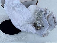 figurine wrapped in tissue with black oval pad visible