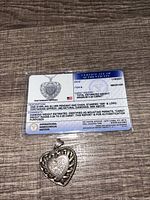 Front view of pendant and certificate showing design and gem details