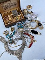 Entire lot spread out showing necklaces, bracelets, brooches, earrings and jewellery box