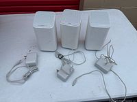 Front/top view of three Xfinity gateways with power adapters