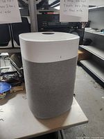 Front view of cylindrical Blueair purifier showing grey fabric sleeve and white top