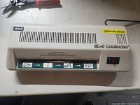 Front/top view of Ibico GL-9 laminator showing feed slot, icons, power switch