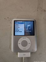 Front view of iPod Nano powered on showing menu and song count