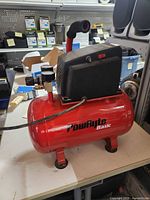 Left front view showing PowRyte Basic logo, red tank, motor housing, handle and feet