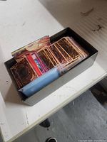 Open box showing stack of Yu-Gi-Oh! cards, many in sleeves