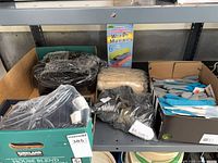 Three boxes on shelf holding assorted gloves and unopened six-pack