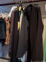 Clothing rack showing variety of blazers, sweaters, scarves