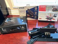 Retail boxes for Vu monitor stand, Epson V300 scanner, Ion Profile LP turntable with loose monitor stand components