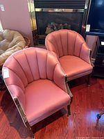 Front view of both pink fan-back chairs showing design and condition