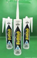 Three cartridges of Powerseal ProLine 201 clear silicone sealant with nozzles attached
