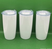 front view of three identical white tumblers with lids fitted