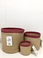 Three Alkaso jute baskets standing side by side showing size differences and attached tags