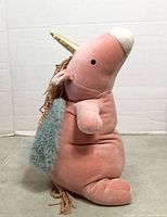 Side view of pink Pegasus weighted plush showing overall shape, horn, wing, and limbs