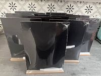 Front view of multiple shrink-wrapped black chalkboards in wood bases with chalk sticks