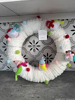 Front view of full white yarn wreath with felt birds